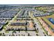 Expansive aerial view of a suburban neighborhood with orderly streets, complemented by a scenic pond and golf course at 1554 Plunker Dr, Davenport, FL 33896