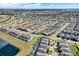 Overhead view of a Primary-planned community featuring diverse home styles, green spaces, and a tranquil pond at 1554 Plunker Dr, Davenport, FL 33896
