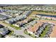 An aerial view shows residences in a community, some featuring screened-in pools, set against a backdrop with a small lake at 1554 Plunker Dr, Davenport, FL 33896