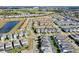 Scenic aerial shot of a neighborhood near a pond and golf course with a variety of home styles and lush landscaping at 1554 Plunker Dr, Davenport, FL 33896