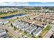 An aerial view captures residences in a community, some featuring screened-in pools, set against a backdrop with a small lake at 1554 Plunker Dr, Davenport, FL 33896