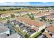 An aerial view captures residences in a community, some featuring screened-in pools, set against a backdrop with a small lake at 1554 Plunker Dr, Davenport, FL 33896