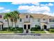 Well-maintained condo exterior features lush landscaping, palm trees, and a tile roof at 1554 Plunker Dr, Davenport, FL 33896