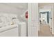 Functional laundry room equipped with washer, dryer, storage shelves, and ample space for laundry tasks at 1554 Plunker Dr, Davenport, FL 33896