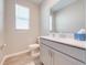 Light-filled bathroom with a window and a gray vanity at 1860 Tohoqua Blvd, Kissimmee, FL 34744