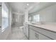 Well-lit bathroom featuring double vanity, large mirror, and glass-enclosed tiled shower at 1860 Tohoqua Blvd, Kissimmee, FL 34744