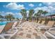 Rows of lounge chairs next to the sparkling blue community pool and palm trees on a sunny day at 1860 Tohoqua Blvd, Kissimmee, FL 34744