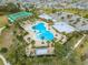 Aerial view of the community pool, tennis courts, playground, parking, and homes in a well-maintained neighborhood at 1860 Tohoqua Blvd, Kissimmee, FL 34744