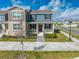 Charming two-story townhome with a welcoming front porch, landscaped yard, and brick pathway at 1860 Tohoqua Blvd, Kissimmee, FL 34744