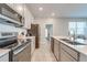 Updated kitchen with stainless steel appliances, quartz countertops and view into living room at 1860 Tohoqua Blvd, Kissimmee, FL 34744