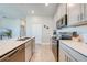 Modern kitchen features stainless appliances, quartz countertops and a view to the living room at 1860 Tohoqua Blvd, Kissimmee, FL 34744