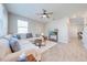 Bright living room boasts a large sectional sofa, ceiling fan, and adjacent hallway at 1860 Tohoqua Blvd, Kissimmee, FL 34744