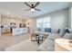 Open concept living room featuring a large sofa, kitchen with island, and abundant natural light at 1860 Tohoqua Blvd, Kissimmee, FL 34744
