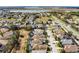 Wide angle neighborhood aerial showcasing homes near a road and lake in a well-planned community at 240 Minniehaha Cir, Haines City, FL 33844