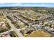 Wide aerial view of neighborhood showcasing organized streets, green spaces, and many homes with private backyard pools at 240 Minniehaha Cir, Haines City, FL 33844