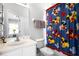 Bright bathroom featuring a vanity with mirror, toilet, and a playful Mickey Mouse shower curtain at 240 Minniehaha Cir, Haines City, FL 33844
