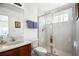 Well-lit bathroom featuring a glass-enclosed shower, a marble vanity, and neutral-toned walls at 240 Minniehaha Cir, Haines City, FL 33844