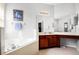 Bathroom featuring a soaking tub with tile surround, sink, and vanity at 240 Minniehaha Cir, Haines City, FL 33844
