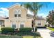 Inviting two-story home featuring a well-manicured lawn, lush landscaping, and a mature palm tree at 240 Minniehaha Cir, Haines City, FL 33844