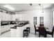 Eat-in kitchen with white cabinets, black countertops, stainless appliances, and table with seating for four at 240 Minniehaha Cir, Haines City, FL 33844