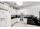 Well-lit kitchen with white cabinets, black countertops, stainless steel sink, and modern appliances at 240 Minniehaha Cir, Haines City, FL 33844