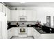 Bright kitchen with sleek black countertops, white cabinets, and modern stainless steel appliances at 240 Minniehaha Cir, Haines City, FL 33844