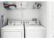 A laundry room with a white washer, dryer and shelving at 240 Minniehaha Cir, Haines City, FL 33844
