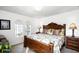 Comfortable main bedroom with a stately wooden bed frame, plush pillows, and two arched windows at 240 Minniehaha Cir, Haines City, FL 33844