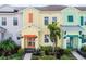 Charming yellow townhome exterior with a pop of orange, complemented by lush landscaping and a welcoming entrance at 2960 Caribbean Soul Dr, Kissimmee, FL 34747