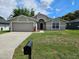 Charming single-story home with neutral paint, arched entry, two car garage, and simple landscaping at 304 Lake Daisy Loop, Winter Haven, FL 33884