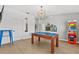 Entertainment room with a wooden pool table, classic arcade game, cool light fixture, and bright flooring at 3137 Sun Lake Ct # B, Kissimmee, FL 34747