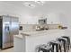 Bright kitchen boasts white cabinets, stainless steel appliances, breakfast bar, and modern stools at 3137 Sun Lake Ct # B, Kissimmee, FL 34747
