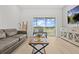 Bright and airy living room with a view to the screened in balcony, a gray sofa, and stylish decor at 3137 Sun Lake Ct # B, Kissimmee, FL 34747