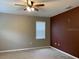Bedroom featuring neutral carpet, dark accent wall, ceiling fan, and a large window with blinds at 3742 Maidencain St, Clermont, FL 34714