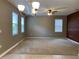 Living room showcasing tile/carpet flooring, ceiling fan, chandelier, and large windows with lots of light at 3742 Maidencain St, Clermont, FL 34714