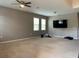 Spacious living room featuring neutral carpet, ceiling fan, and multiple windows for natural light at 3742 Maidencain St, Clermont, FL 34714