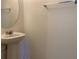 Simple powder room featuring a pedestal sink, round mirror, and a chrome towel bar at 3742 Maidencain St, Clermont, FL 34714
