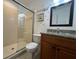 A well-lit bathroom featuring a glass-enclosed shower, granite countertop, and a decorative mirror at 375 Orange Cosmos Blvd, Davenport, FL 33837