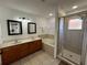 Well-lit bathroom featuring dual sinks, a soaking tub, and a glass-enclosed shower at 375 Orange Cosmos Blvd, Davenport, FL 33837