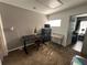 Neutral bedroom featuring a desk, a small loveseat, and an open doorway to another room at 375 Orange Cosmos Blvd, Davenport, FL 33837