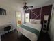 Comfortable bedroom with a queen-sized bed, ceiling fan, decorative accent wall, and desk area at 375 Orange Cosmos Blvd, Davenport, FL 33837