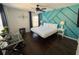Sunlit bedroom with a queen bed, a desk, and hardwood flooring offers a cozy and functional space at 375 Orange Cosmos Blvd, Davenport, FL 33837
