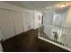 The upstairs hallway features brown carpet, white walls, and a stairway with white banisters at 375 Orange Cosmos Blvd, Davenport, FL 33837