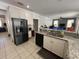 Open kitchen with granite countertops and stainless appliances, adjacent to a bright living area at 375 Orange Cosmos Blvd, Davenport, FL 33837