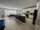Open kitchen features a large island with bar seating, white cabinets, and adjacent dining area overlooking pool at 375 Orange Cosmos Blvd, Davenport, FL 33837