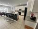 A modern kitchen boasts granite countertops, tile flooring, and white cabinetry with stainless steel appliances at 375 Orange Cosmos Blvd, Davenport, FL 33837