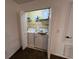 Bright, small laundry room with washer, dryer, shelving and cleaning supplies at 375 Orange Cosmos Blvd, Davenport, FL 33837