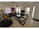 A cozy living room featuring tile floors, a large sectional sofa, lots of natural light, and a ceiling fan at 375 Orange Cosmos Blvd, Davenport, FL 33837