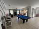 Bright living room featuring a pool table, graphic wall accent, and access to outdoor living at 375 Orange Cosmos Blvd, Davenport, FL 33837