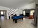 Spacious living room with a pool table, graphic wall decor, and tile flooring at 375 Orange Cosmos Blvd, Davenport, FL 33837